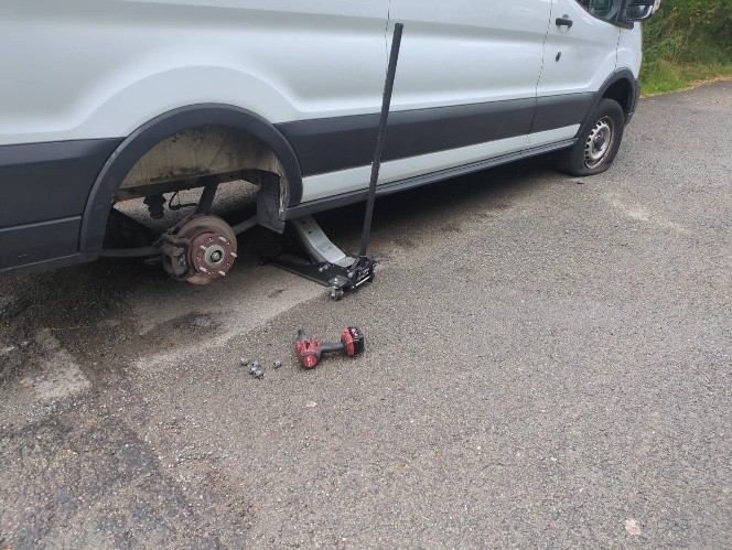 a van is being jacked up and a tyre has been removed